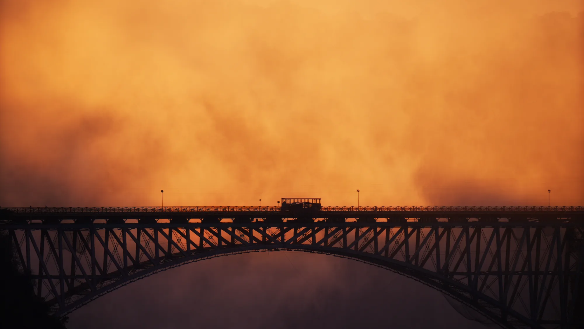 The Bamba Tram crossing the Victoria Falls Bridge at sunrise
