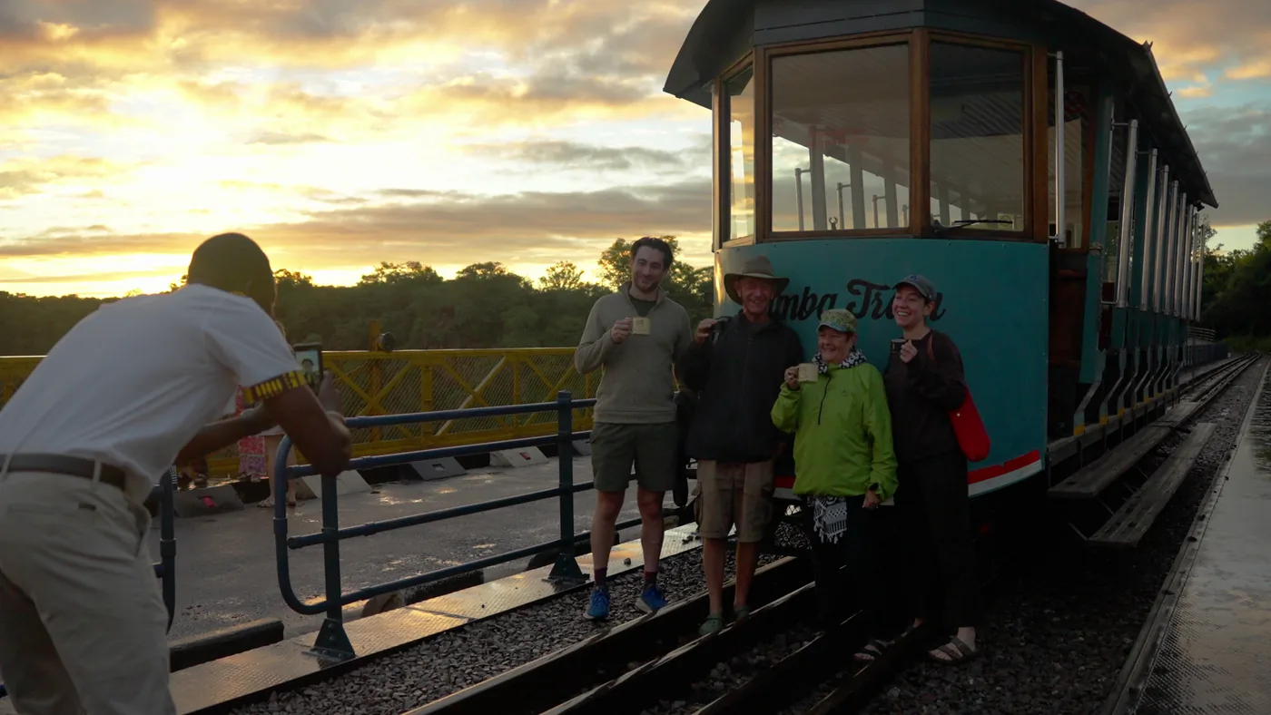Guests posing with the Bamba Tram on the bridge at sunrise